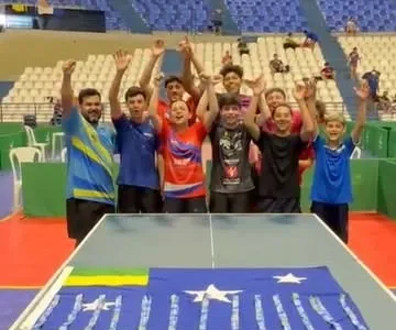Atletas comemorando com as medalhas sobre a mesa